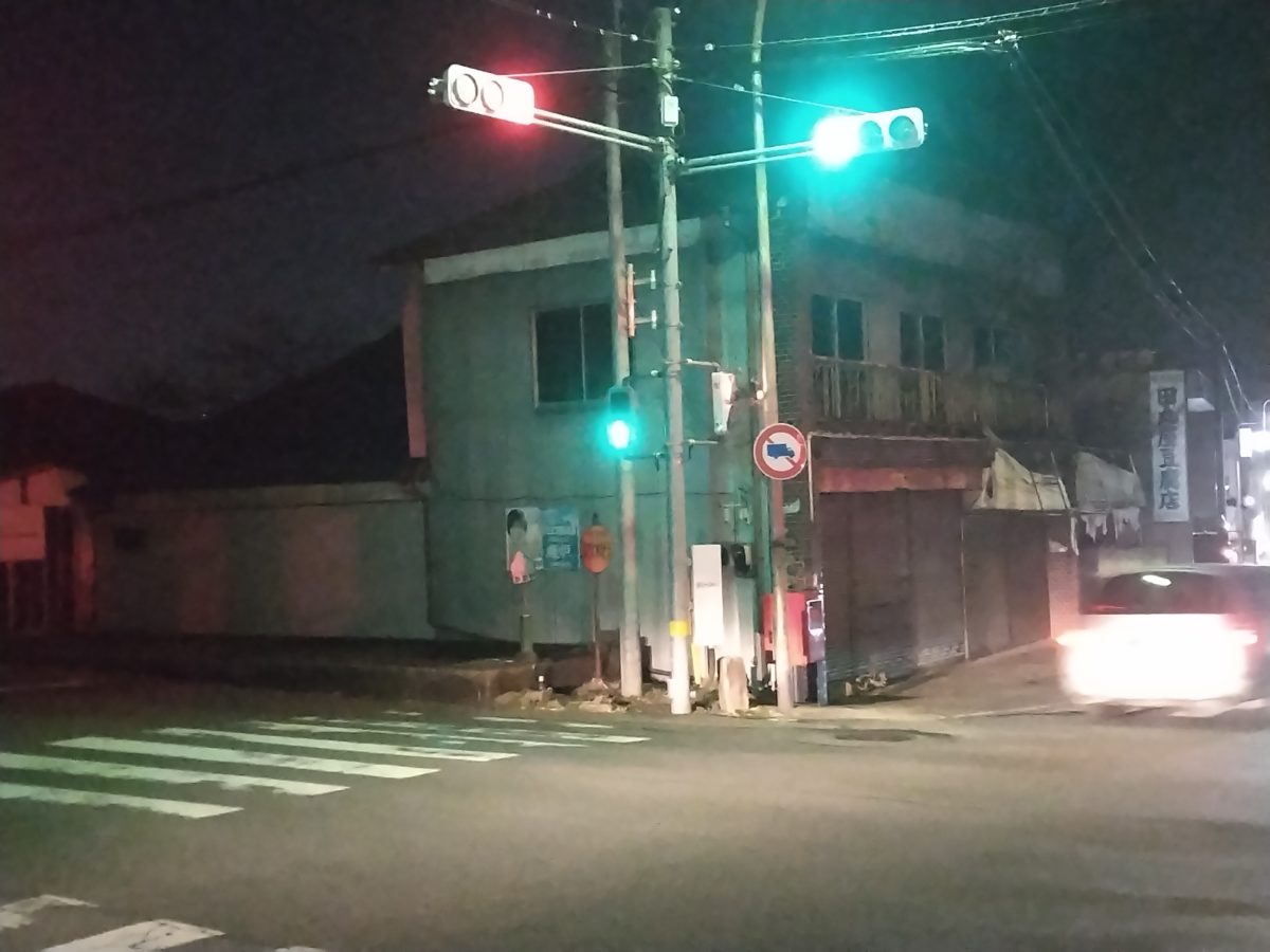 夜の谷田部交差点、光り輝く信号機と通過する車の光跡